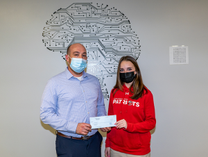 Photo of Laney Higgins presenting USF Concussion Center Director, Dr. Byron Moran, with a check