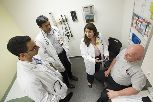 Walter Chapin (far right) talks with his health care team, from left, Karin Hussein, first-year medical student, Santosh Reddy, MD, second-year resident, and Dr. Crystal Jacovino.