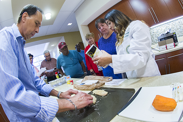 Jerry Brown offers cooking tips for eating better carbs, as Dr. Jacovino reads a product label showing nutrition content.